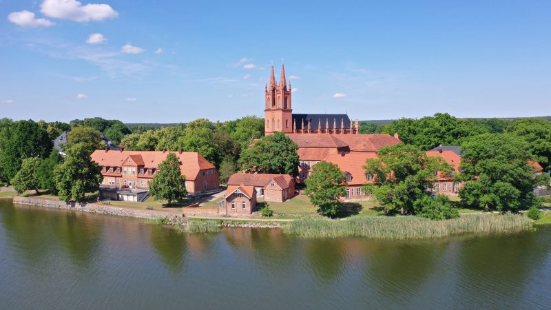 Klosterkirche Dobbertin mit zwei Kirchtürmen und weiteren Gebäuden am See